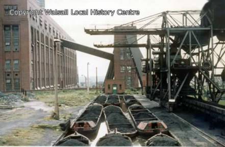 An image from A click in Time, Walsall councils online repository of images around the borough. This image shows the basin full of loaded boats awaiting the cranes ministrations. The coal was unloaded by grab and then dropped on the travelator which carried the coal into the power stations furnaces.